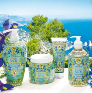 Four Capri-themed bath and body products displayed outdoors with a coastal view in the background.