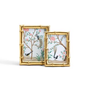 Two gold bamboo-style picture frames with bird and floral illustrations inside, one larger and one smaller, side by side.