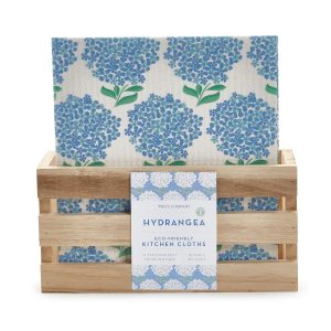 A set of hydrangea-printed eco-friendly kitchen cloths displayed in a small wooden crate.