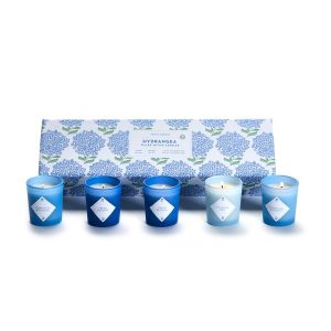 A set of five blue and white votive candles placed in front of a floral-patterned Hydrangea gift box.