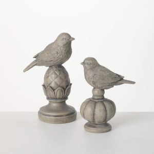 Two stone bird figurines are perched on decorative pedestal bases against a plain white background.