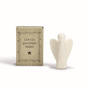 A small white angel figurine stands next to a box labeled "Little guardian angel" with a star symbol.