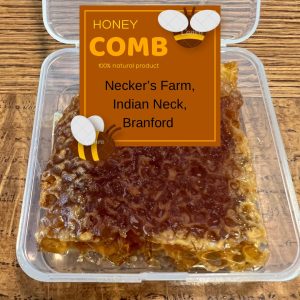A clear container holds a piece of honeycomb with a label from Necker’s Farm, Indian Neck, Branford.