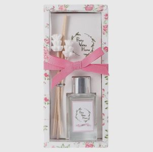 A floral-scented reed diffuser set with a pink ribbon, glass bottle, and decorative box labeled "Pretty Valley Home.