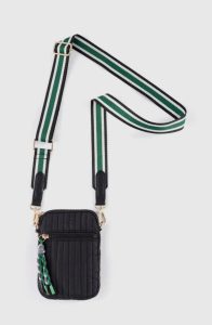 Small black quilted crossbody bag with a green and white striped adjustable strap and decorative keychain.