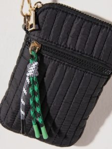 Black quilted zip pouch with a front pocket and a green, white, and black braided keychain attached to the zipper.