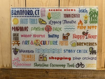 Decorative sign listing Branford, CT attractions and activities with colorful icons and phrases on a wooden background.