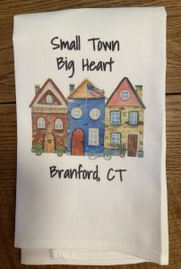 A towel with illustrations of three houses and the text "Small Town Big Heart Branford, CT" printed above and below them.