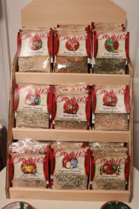 Display rack with eight packets of Carmie's dip and cheese ball mix in various flavors.