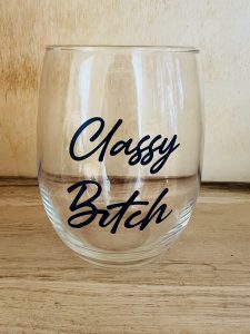 A clear stemless wine glass with the words "Classy Bitch" printed in black script font.