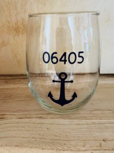 A stemless wine glass with the number 06405 and a navy blue anchor printed on the front.
