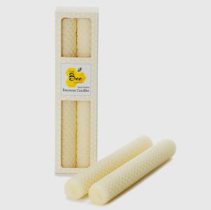 Two rolled beeswax candles with a honeycomb pattern, shown next to their packaging box labeled "Beeswax Candles.