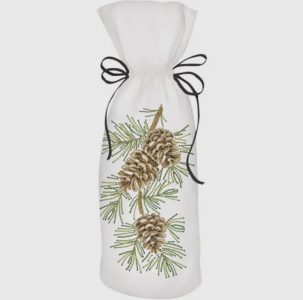 A white fabric bag with pinecone and pine needle embroidery, tied with a black ribbon.