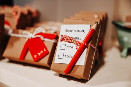 A wrapped gift with a note to Santa, a red pencil, and checkboxes labeled naughty, nice, and I tried.