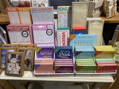 Display of assorted notepads, journals, and gift books with various motivational and organizational themes on a store shelf.