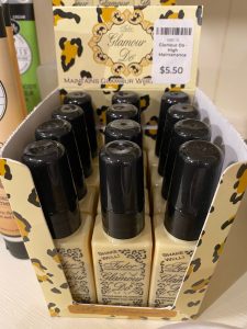 A display box of "Glamour Do" spray bottles, labeled $5.50 each, arranged neatly on a retail shelf.