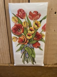 A white towel with an illustration of a bouquet of red and yellow tulips tied with a blue floral ribbon.