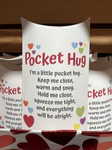 A card labeled "Pocket Hug" with a poem about comfort and reassurance, decorated with colorful hearts.