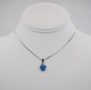 Silver necklace with a blue and white evil eye pendant displayed on a white jewelry bust against a plain background.