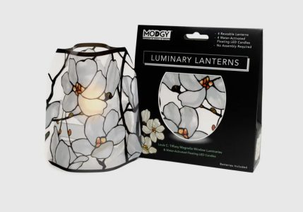 Reusable lantern with a white magnolia flower design is shown next to its Modgy Luminary Lanterns packaging.
