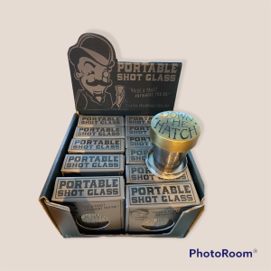 Display box containing "Portable Shot Glass" products, with one metal collapsible shot glass extended and labeled "DOWN THE HATCH.