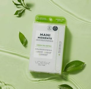 A VOESH Mani Moments Green Tea Detox kit is displayed on a light green surface with green leaves around it.
