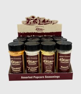 Display box of Amish Country assorted popcorn seasonings, including cheddar cheese, sour cream & onion, white cheddar, and ranch.